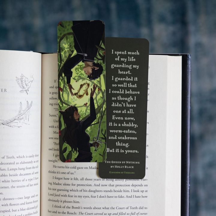 Two green bookmarks in an open book: one with Jude and Cardan. The other side reads ‘I spent much of my life guarding my heart. I guarded it so well that I could behave as though I didn’t have one at all. Even now, it is a shabby, worm-eaten, and scabrous thing. But it is yours.’