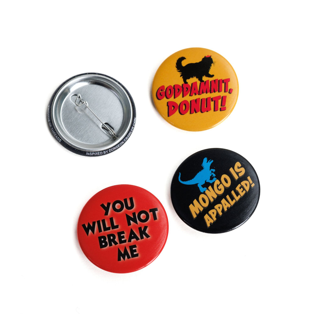 Four button pins themed around the series Dungeon Crawler Carl by Matt Dinniman. One shows the pin back, ‘Goddamnit Donut’ with a cat on it, ‘You will not break me’, and ‘Mongo is appalled’ with a dinosaur on it.
