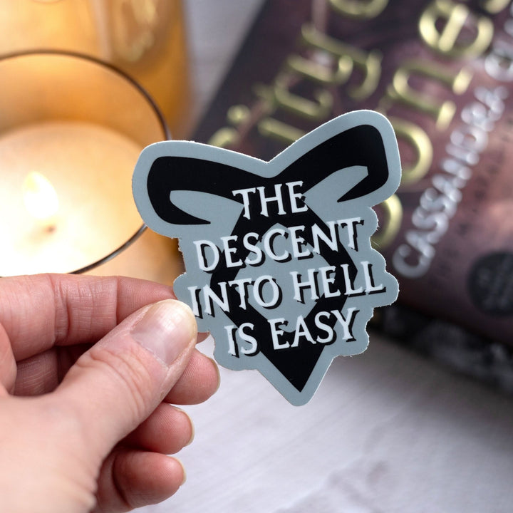 Sticker reads ‘The descent into hell is easy’ with enkeli rune from Shadowhunters, held over City of Bones.