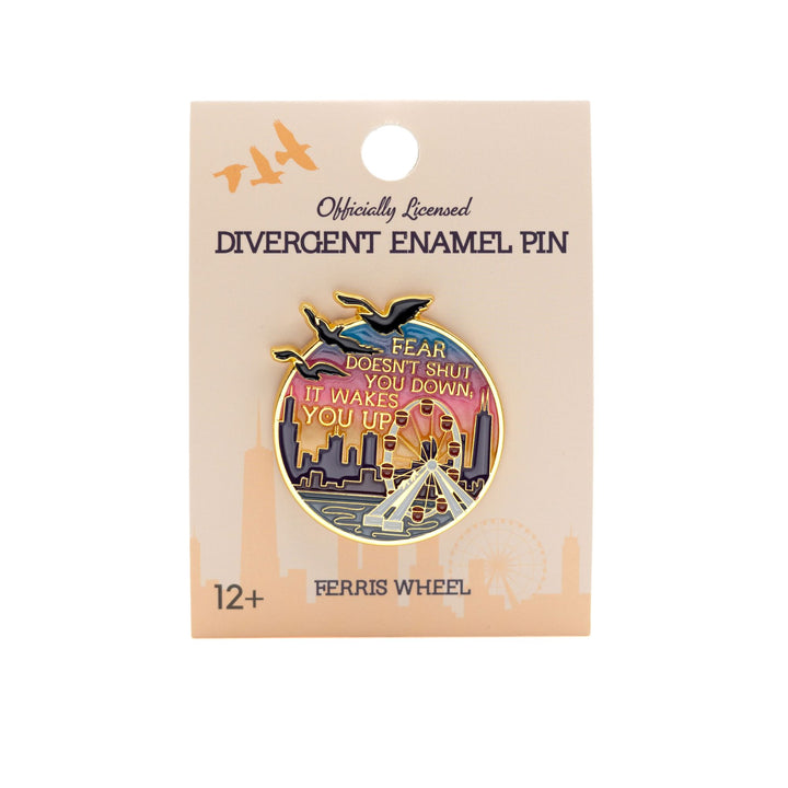Enamel pin of the Navy Pier Ferris wheel at sunset with the Divergent quote ‘Fear doesn’t shut you down, it wakes you up.’ in gold metal on a tan backer card.