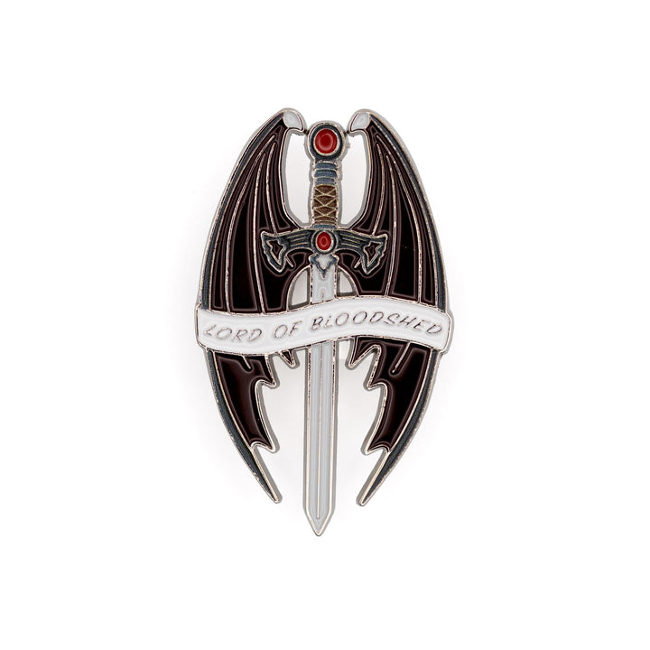 Enamel pin of a sword with a red stone and pommel, surrounded by bat wings that reads ‘Lord of Bloodshed’ on a white ribbon. 