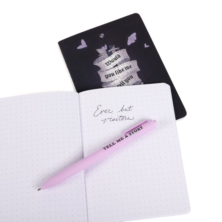Dark purple A6 journal behind an open A6 dot grid journal with purple pen and handwritten note: ‘Ever but visitors.’