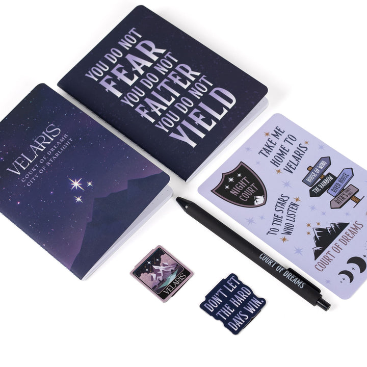 Gift set laid out: A6 ‘Velaris’ and ‘You do not fear you do not falter you do not yield’  & books journals, ACOTAR Velaris  sticker sheet, Velaris  & “Don’t let the hard days win” magnetic bookmarks, black pen.