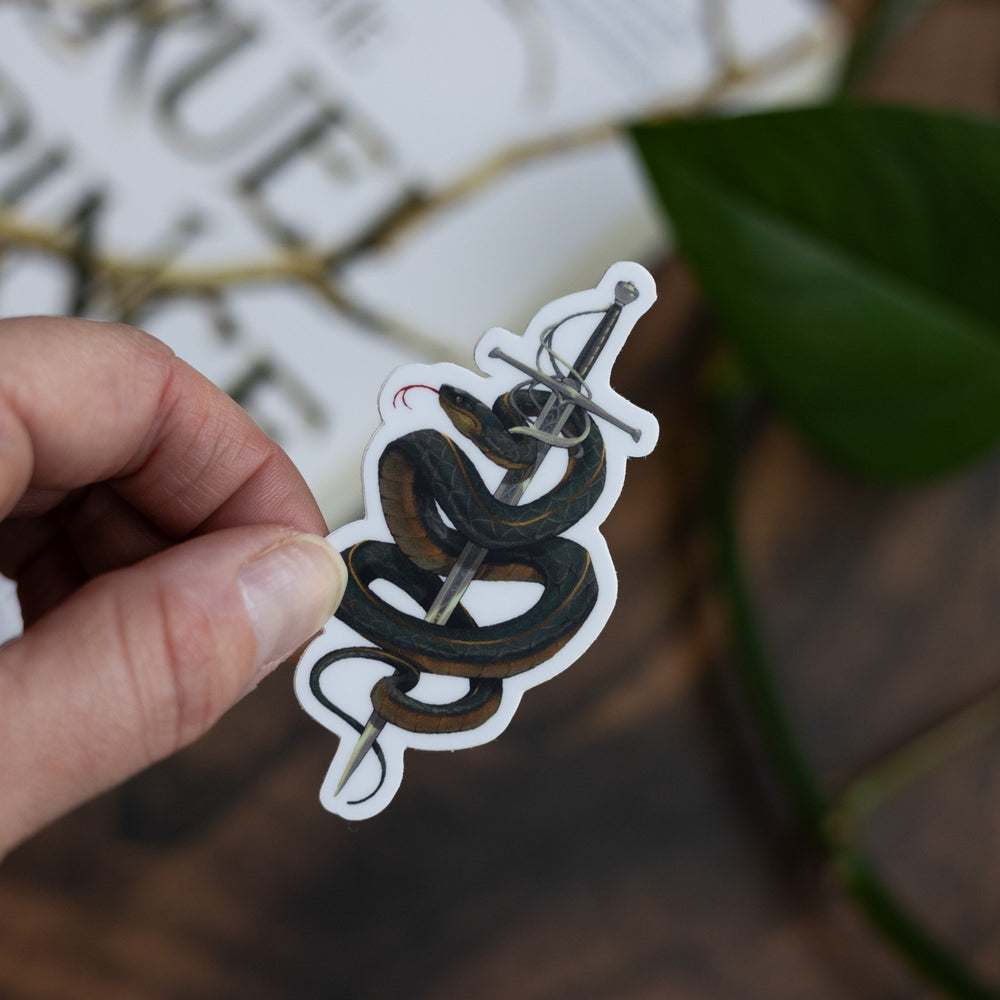 Sticker of Cardan from The Cruel Prince in serpent form, wrapped around the sword Nightfell, held above The Cruel Prince.