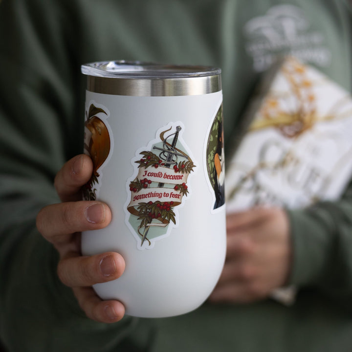 Sticker of the sword Nightfell with a banner ‘I could become something to fear’ and rowan berries on a white cup.