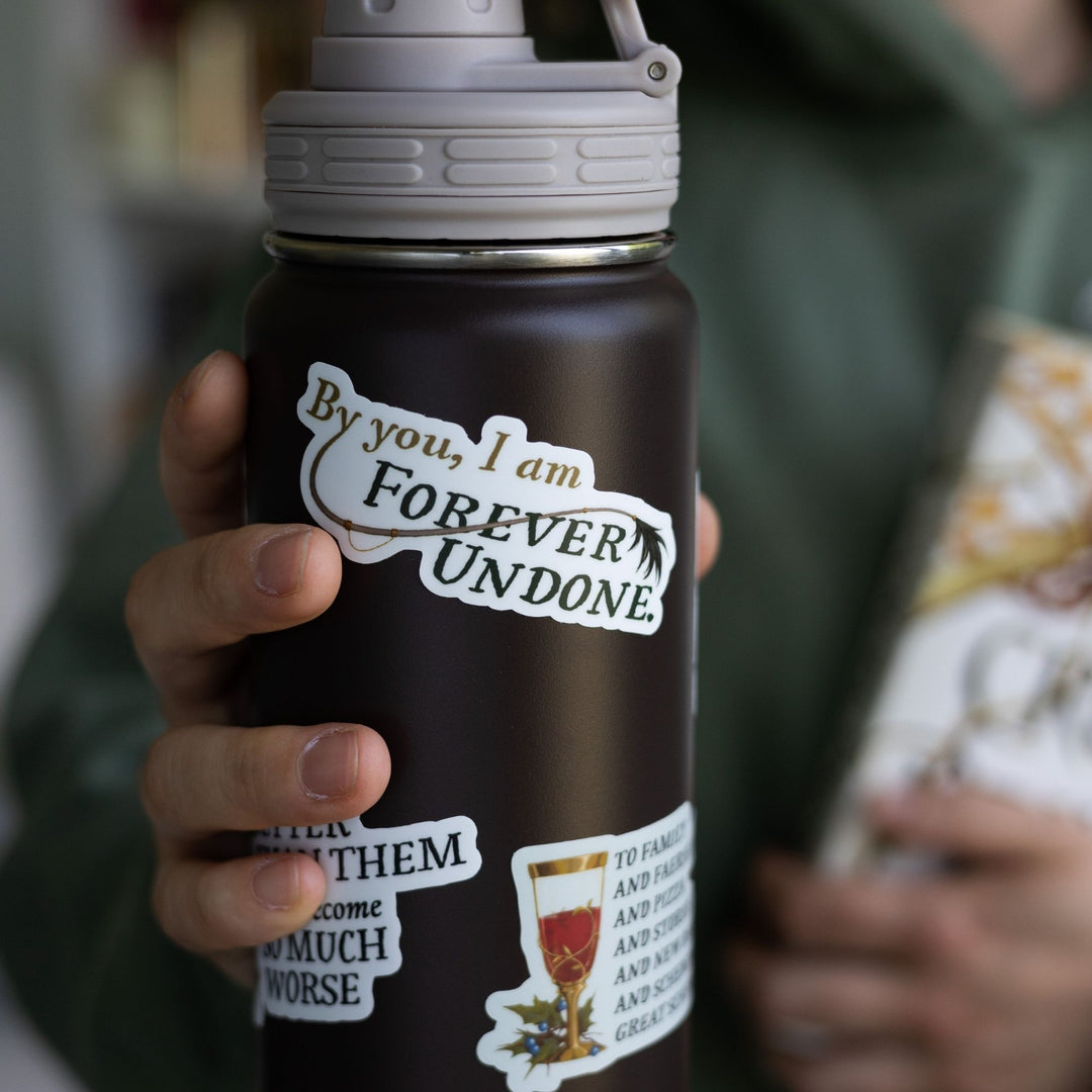 The Cruel Prince quote sticker on a black water bottle: ‘By you, I am forever undone’ with Cardan’s tail. 