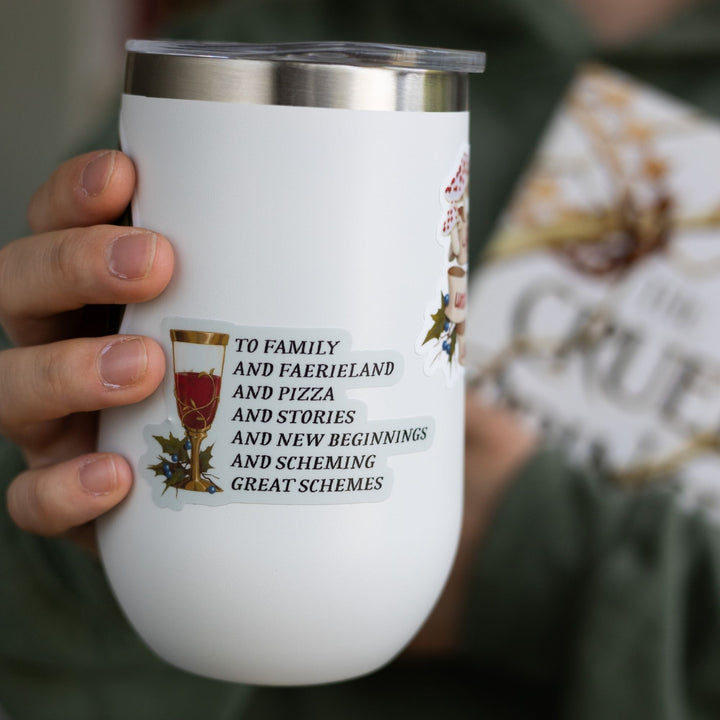 Cruel Prince quote sticker on a white tumbler: ‘To family and faerieland and pizza and stories and new beginnings and scheming great schemes’ with a goblet.
