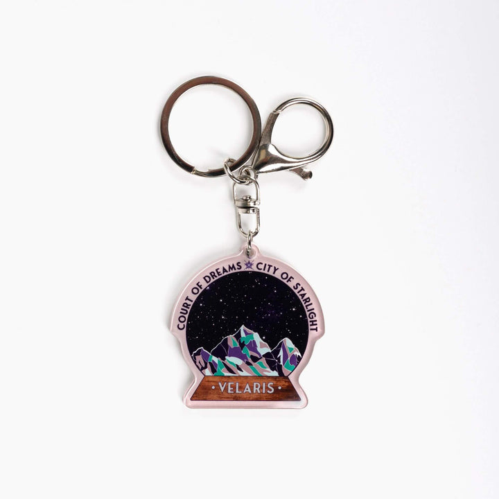  Acrylic keychain of snow globe with mountains against the night sky. 'Court of Dreams City of Starlight' above it. ‘Velaris’ on the base.

