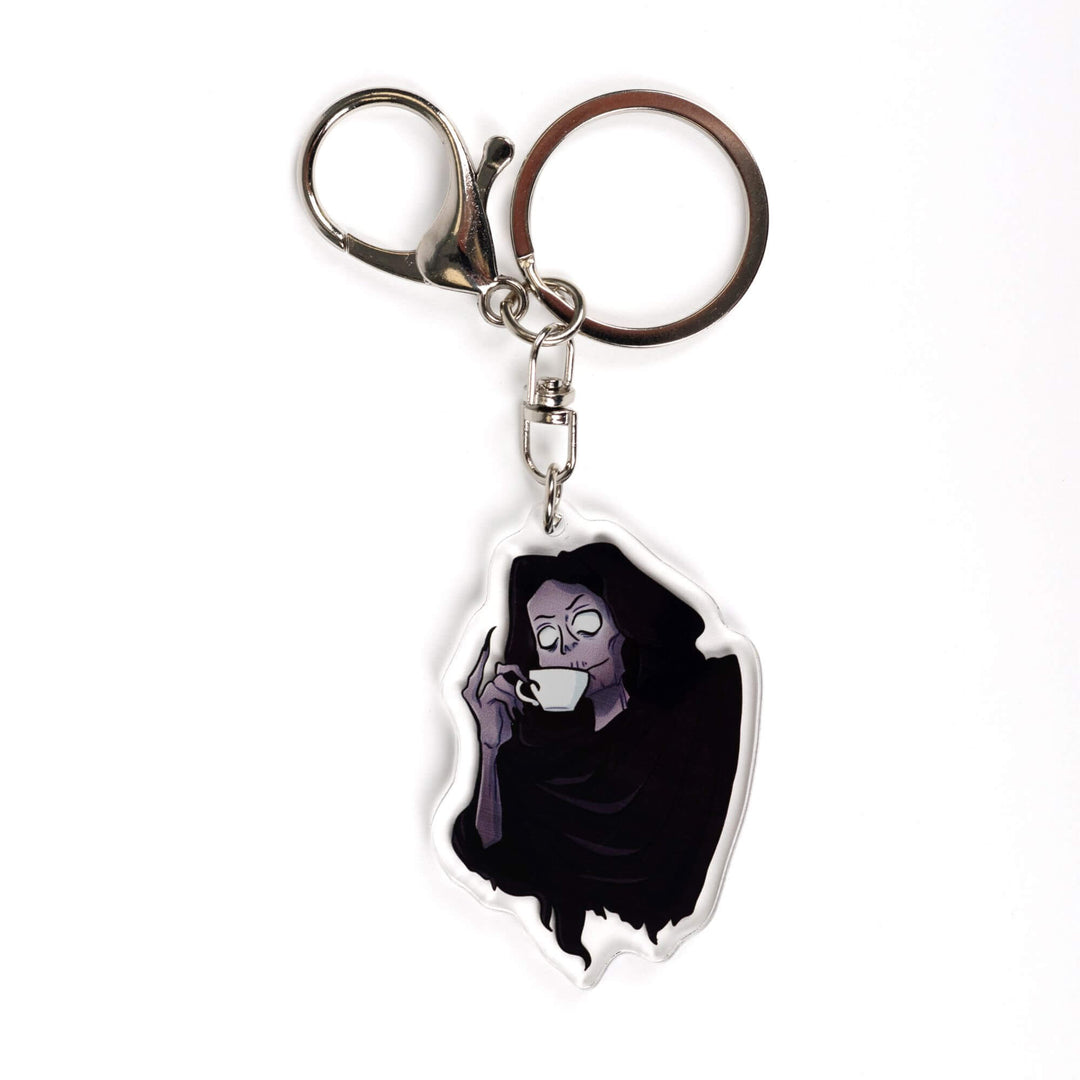 Acrylic keychain of the Suriel from A Court of Thorns and Roses, wearing a hood and sipping from a white tea cup, little finger raised.
