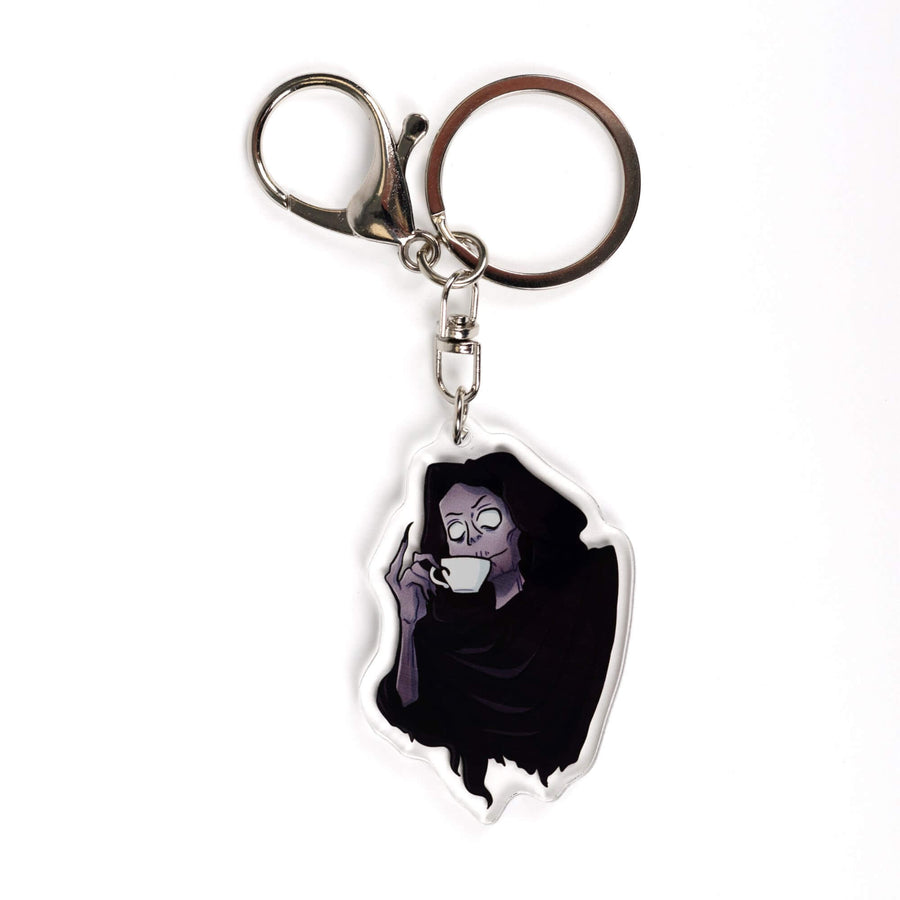 Acrylic keychain of the Suriel from A Court of Thorns and Roses, wearing a hood and sipping from a white tea cup, little finger raised.
