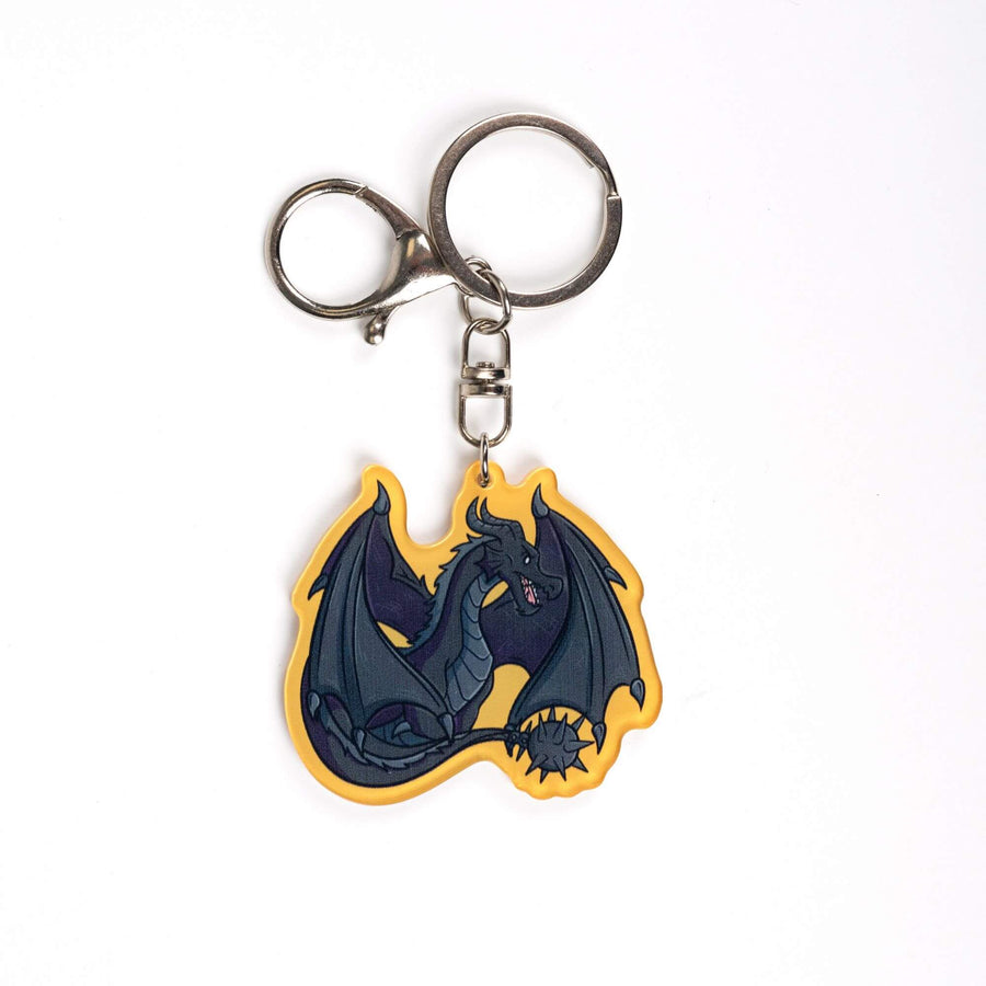 Acrylic keychain of Tairn, black dragon from Fourth Wing, sitting with tail and wings tucked around him. Golden yellow border.
