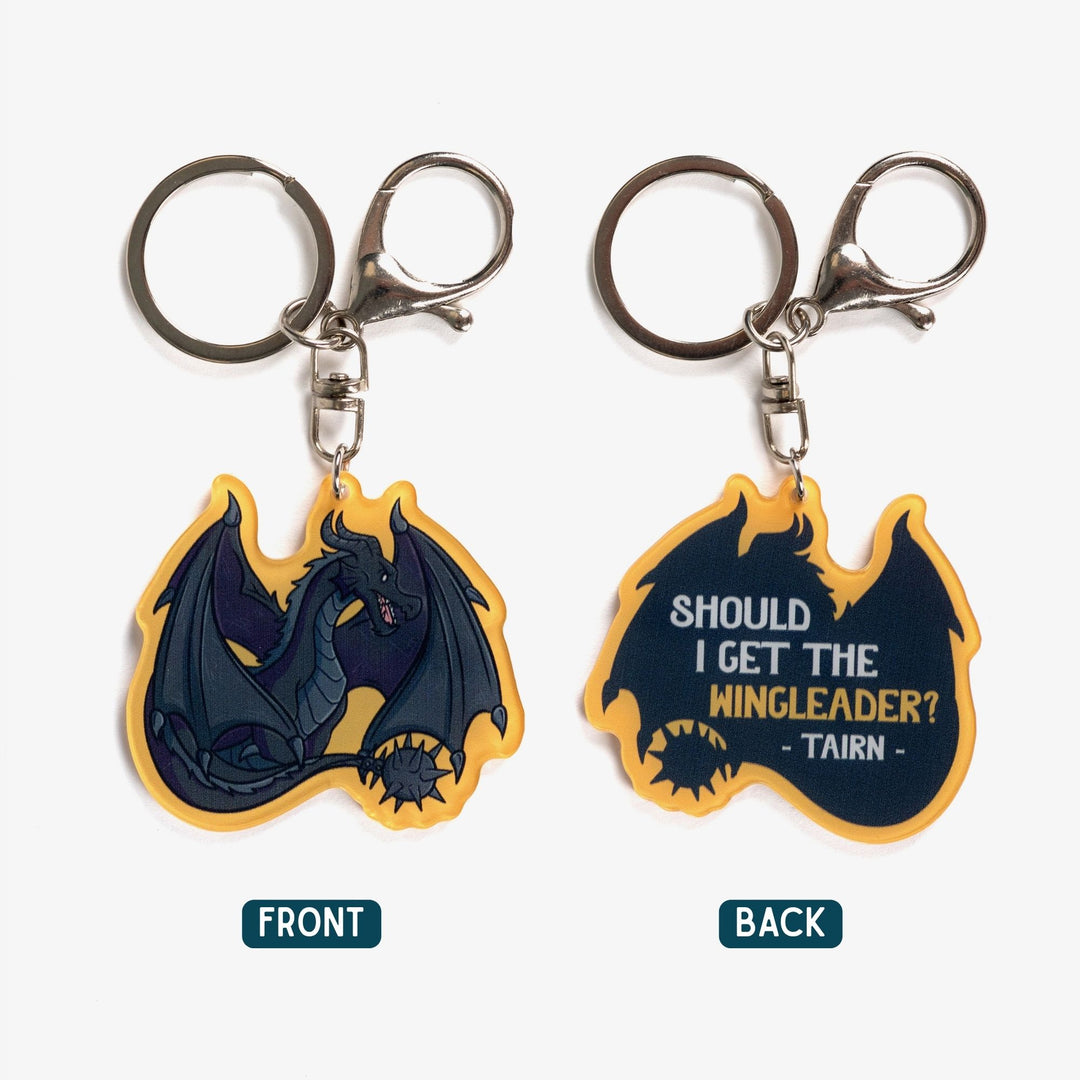  2 acrylic keychains. Tairn, black dragon, sitting on one. The silhouette of the same dragon with ‘Should I get the wingleader? Tairn’ on it. Golden yellow border.
