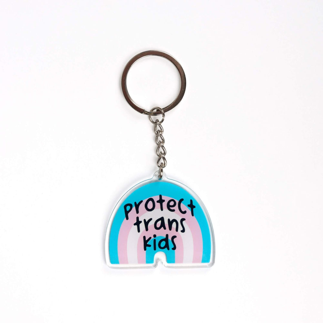 Acrylic keychain of a trans pride rainbow that says ‘Protect trans kids.’ The rainbow is blue, pink, and white.
