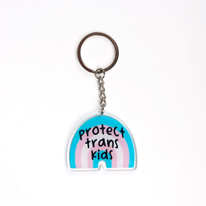 Acrylic keychain of a trans pride rainbow that says ‘Protect trans kids.’ The rainbow is blue, pink, and white.
