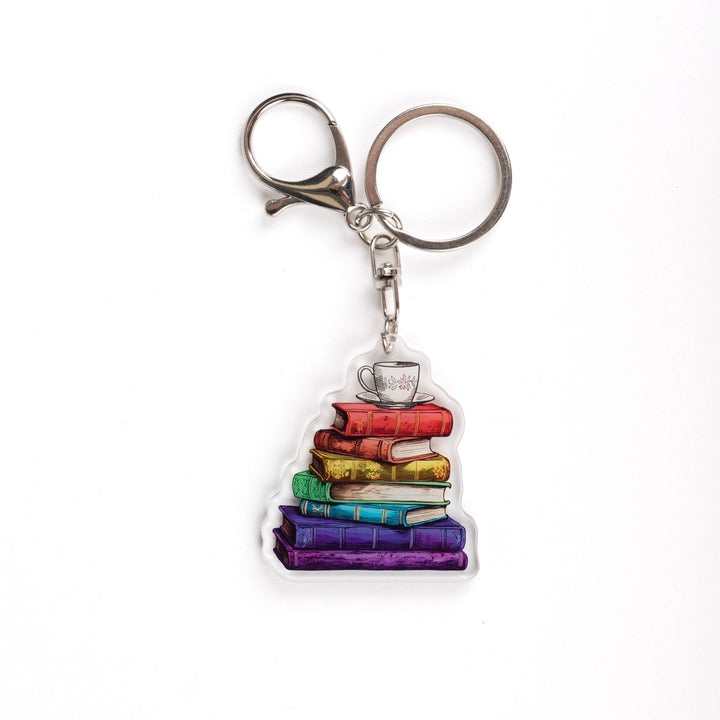 Acrylic keychain of a stack of books that are each a different color of the rainbow with a tea cup with a pink flower and saucer on top.

