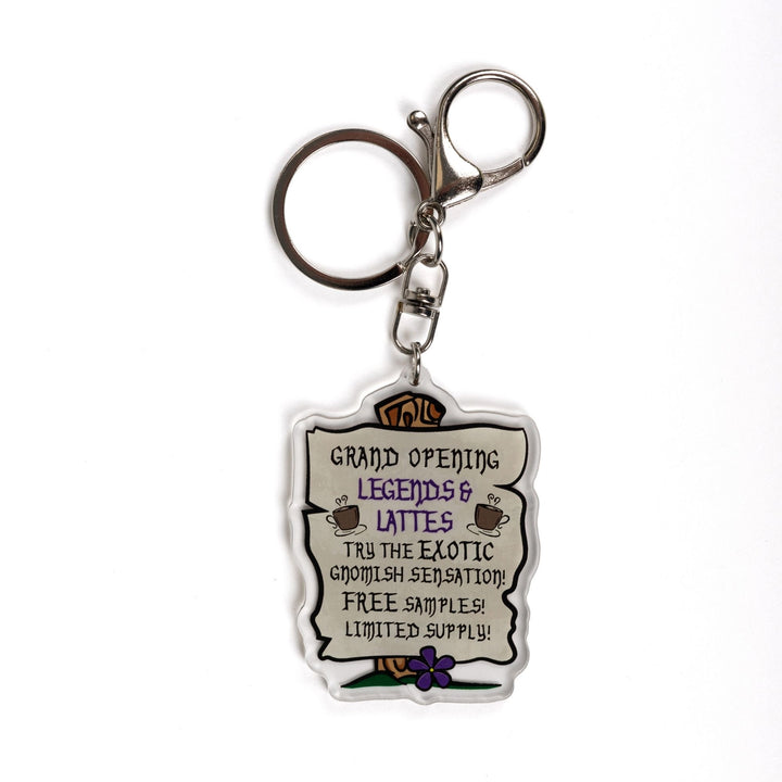 Acrylic keychain of parchment sign nailed to a post: ‘Grand opening. Legends & Lattes. Try the exotic gnomish sensation! Free samples! Limited Supply.' 
