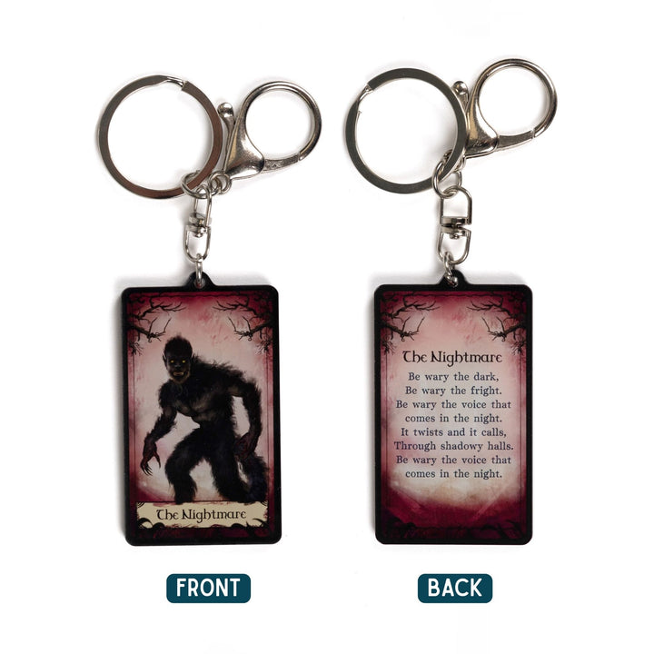 2 acrylic keychains of a tarot card. One says ‘The Nightmare’ with a monster below it. The other is a quote from One Dark Window by Rachel Gillig. 
