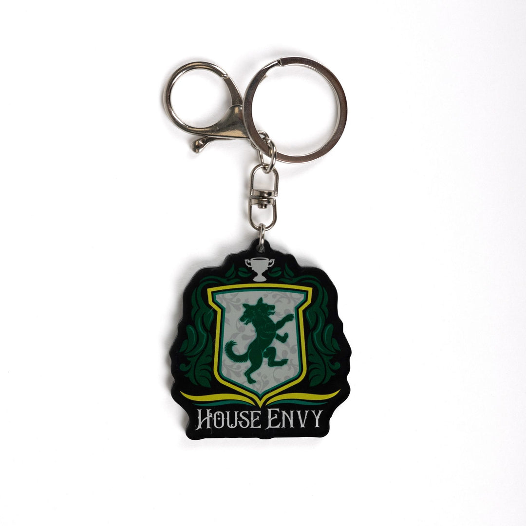 Keychain of a crest with a two headed wolf with green leaves on the side, a trophy on top, and House of Envy in white letters at the bottom. 