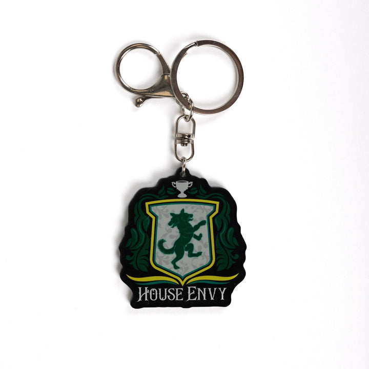 Keychain of a crest with a two headed wolf with green leaves on the side, a trophy on top, and House of Envy in white letters at the bottom. 