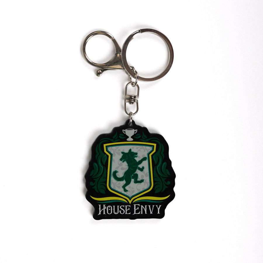 Keychain of a crest with a two headed wolf with green leaves on the side, a trophy on top, and House of Envy in white letters at the bottom. 