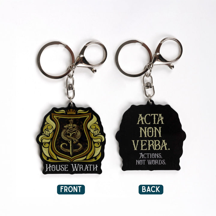  2 acrylic yellow and gold keychains of a house crest. One side has a snake wrapped around a sword and House of Wrath. The other side reads ‘Acta non verba. Actions not words.’
