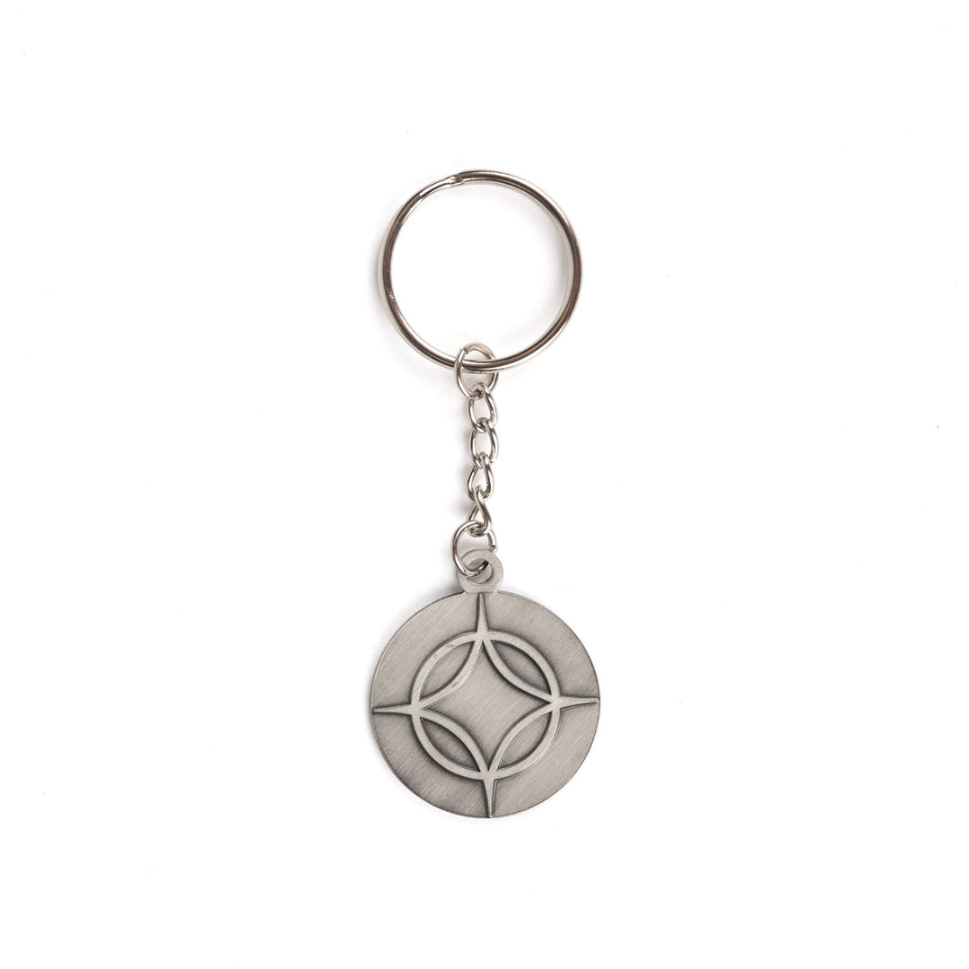 Metal keychain of a circle with a four point star over top. From Legendborn by Tracey Deonn. 
