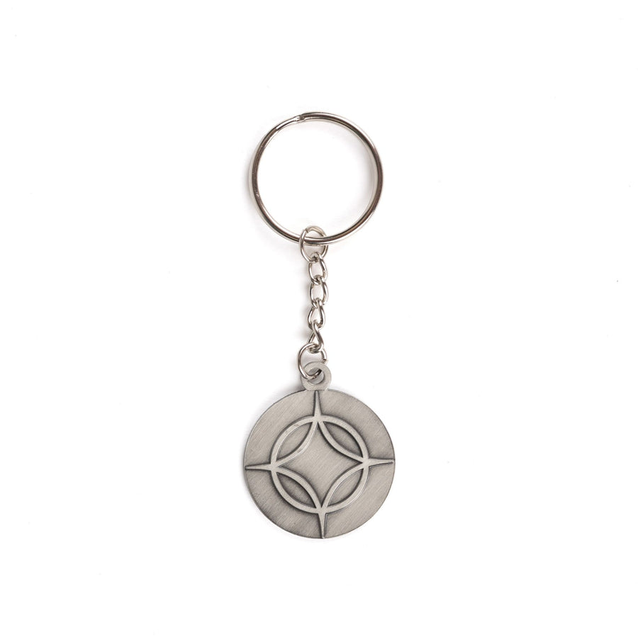 Metal keychain of a circle with a four point star over top. From Legendborn by Tracey Deonn. 
