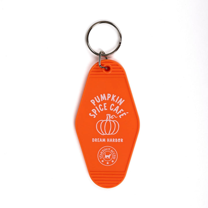  Orange motel-style keychain for ‘Pumpkin Spice Cafe. Dream Harbor’ in white letters with a pumpkin. A circle under that says ‘Stakeout access.’
