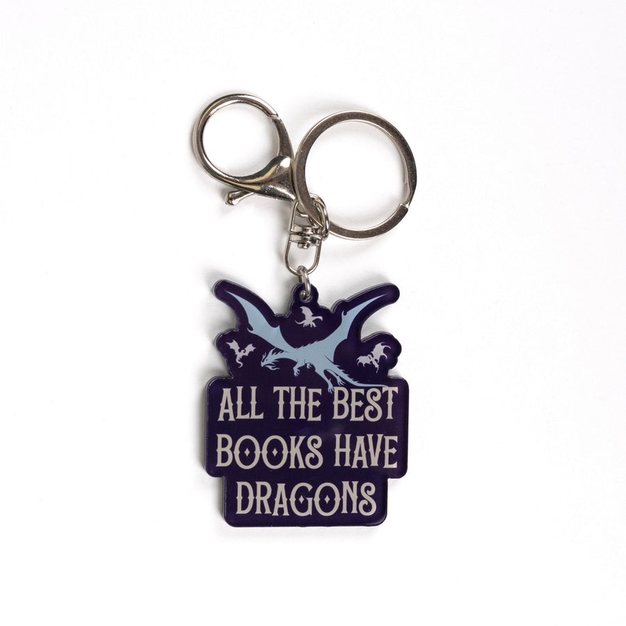 Purple acrylic keychain of one big and three small flying dragons that reads ‘ All the best books have dragons’ in white letters. 
