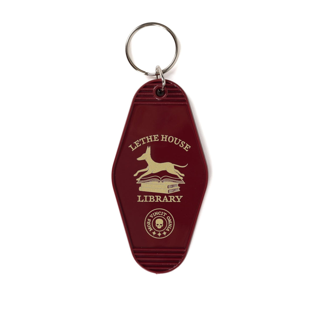 Double sided motel keychain with an illustration of a jackal bounding over a stack of books that reads ‘Lethe House Library, Mors Irrumat Omnia.’
