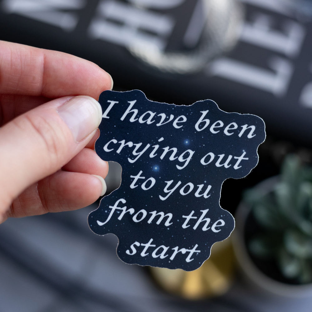   Quote sticker from Ninth House by Leigh Bardugo ‘ I have been crying out to you from the start,’ held above Ninth House.