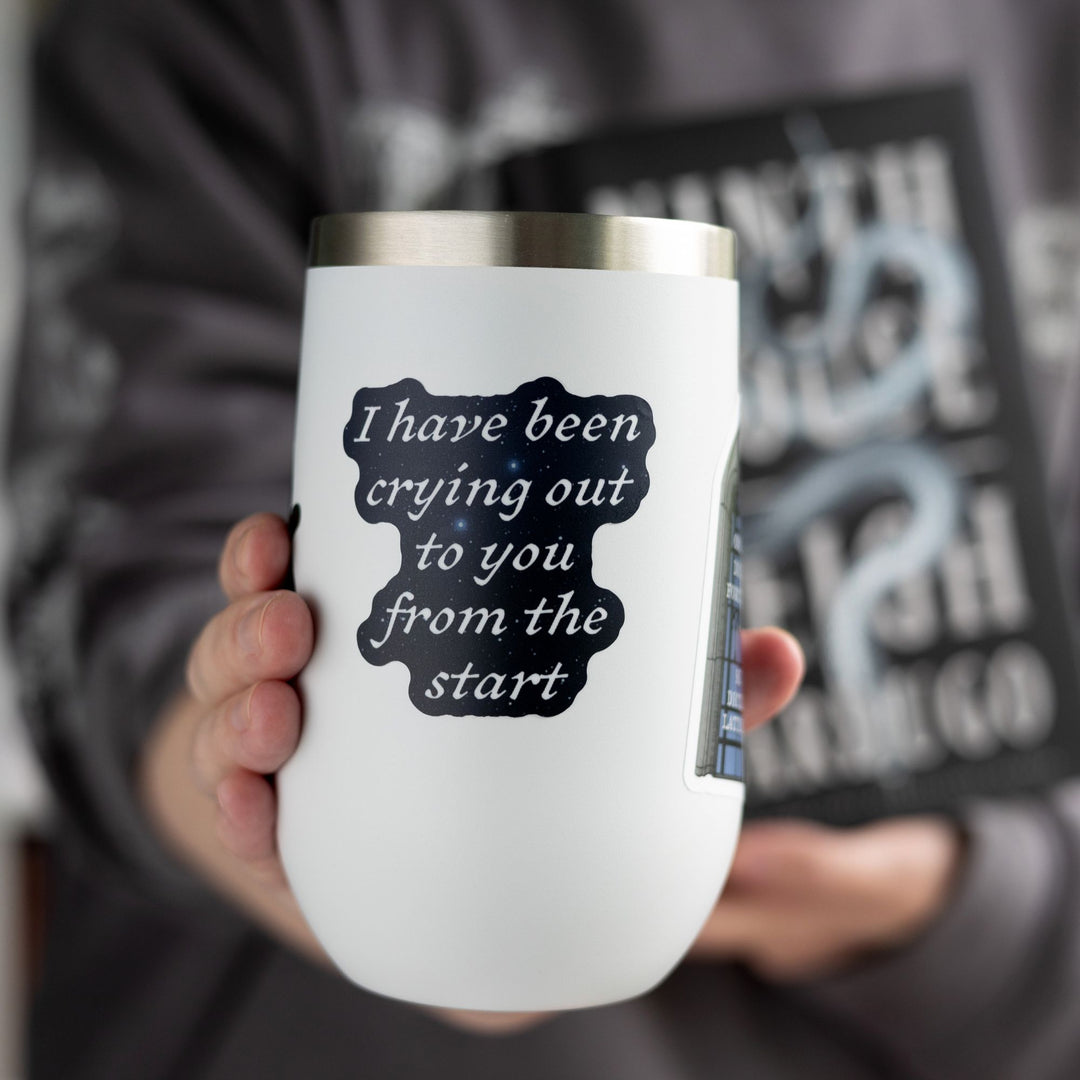 Quote sticker from Ninth House by Leigh Bardugo ‘ I have been crying out to you from the start,’ on a white tumbler.