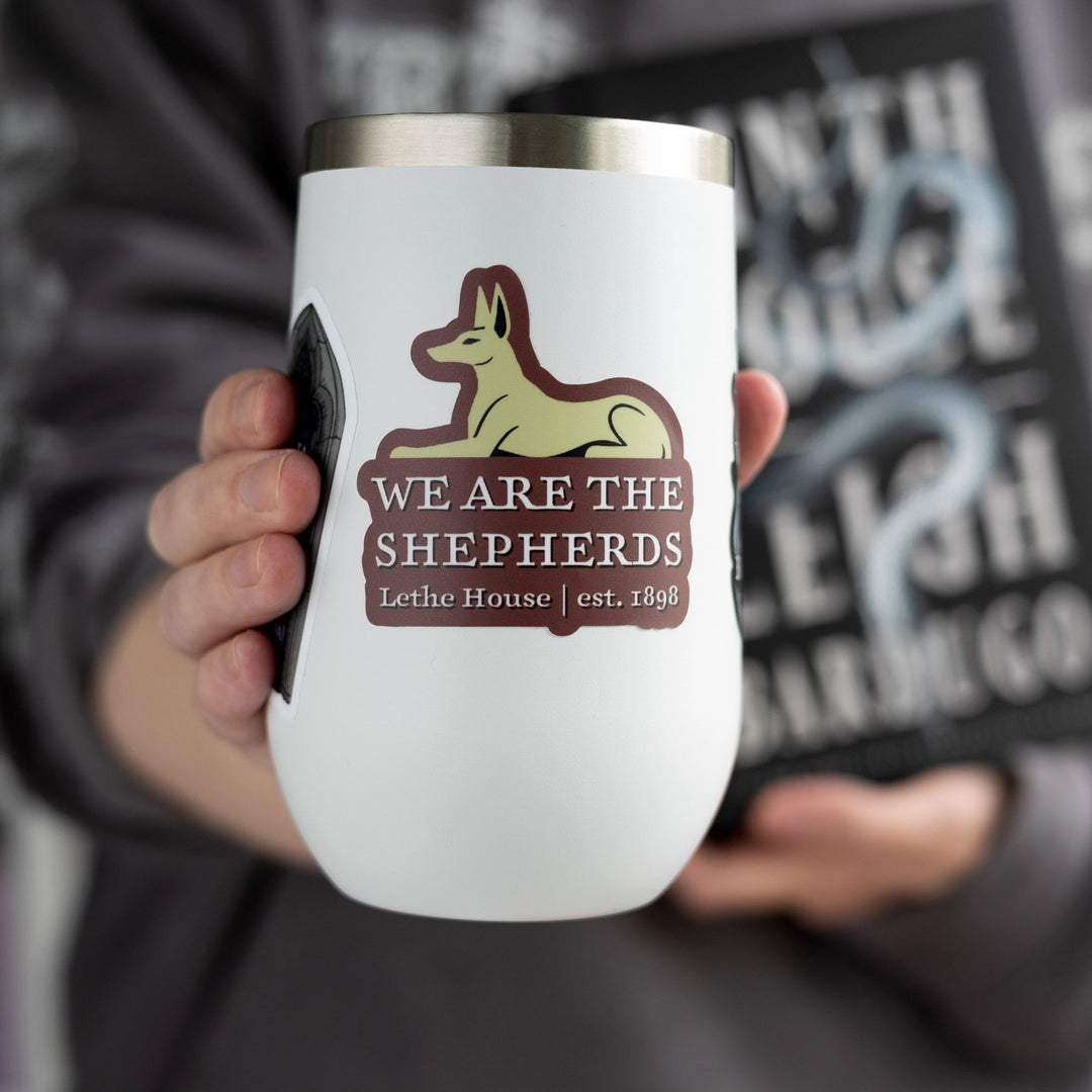 Sticker of Lethe jackal over the words ‘We are the Shepards, Lethe House, est 1898,’ from Ninth House, on a white tumbler.
