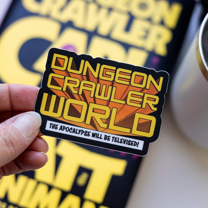 Sticker of 'Dungeon Crawler World' in orange on a black background. 'The Apocalypse Will Be Televised!' is below on a white banner. Held over Dungeon Crawler Carl.
