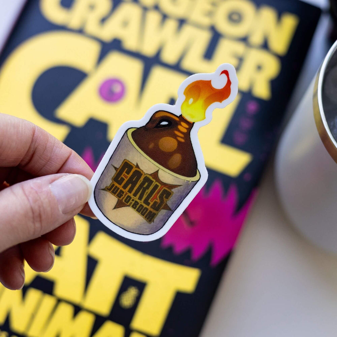  Sticker of an amber glass bottle with a product label that reads ‘Carl’s Jug O Boom’, with flames coming out the top. Held over Dungeon Crawler Carl