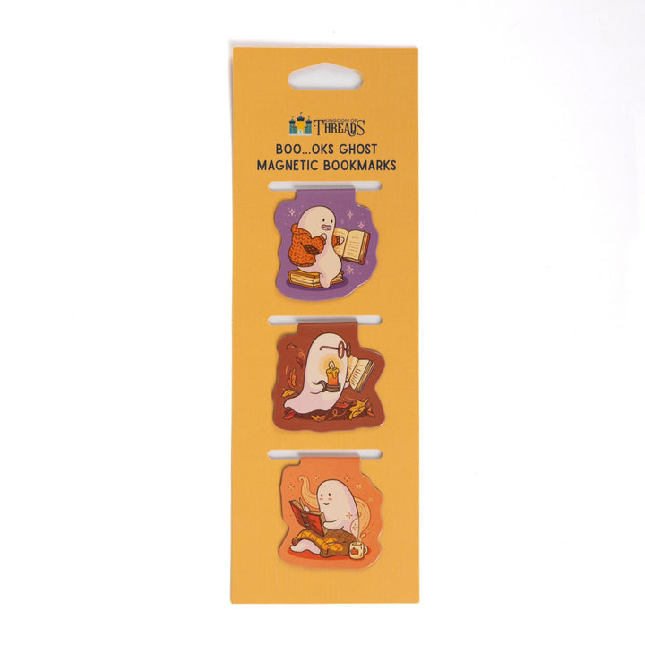 Set of 3 magnetic bookmarks of ghosts reading books arranged vertically on orange cardstock packaging. 