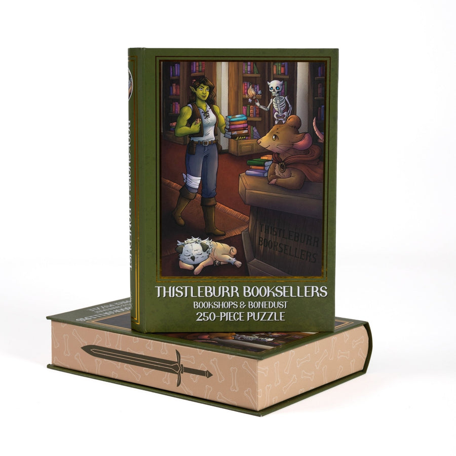 Book-shaped green box for Thistleburr Booksellers Bookshops & Bonedust 250-piece puzzle. Art on the front is of Viv in the bookstore.
