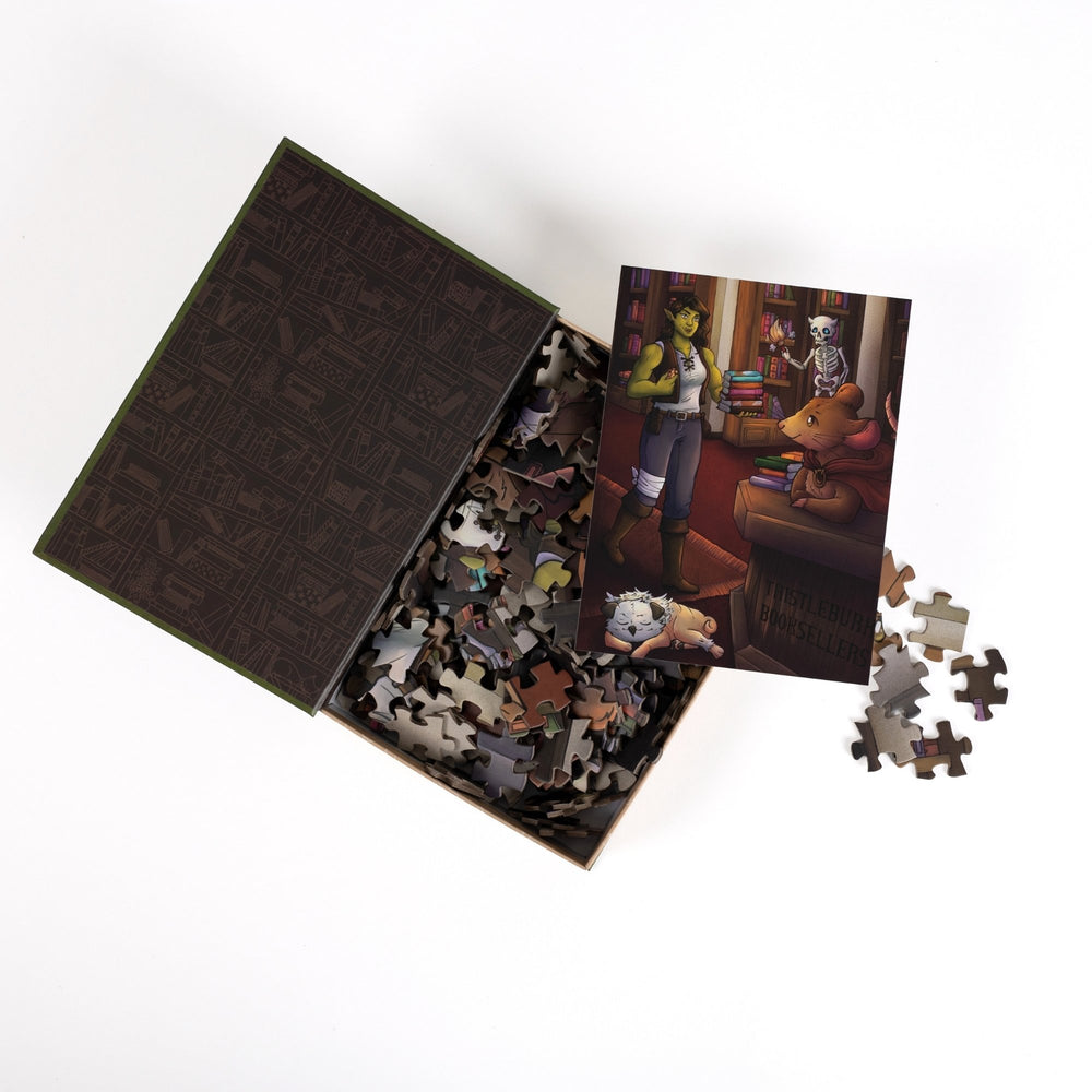 An open book-shaped box reveals puzzle pieces. Pattern of bookshelves in brown on black on inner flap. An art print of Viv in the bookstore atop the pieces.