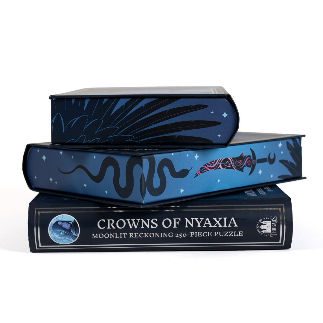 Stack of 3 puzzle boxes showing all sides. Blue edges with a black sword, snake, and feathers and the spine of the box reads Crowns of Nyaxia Moonlit Reckoning 250-piece puzzle.