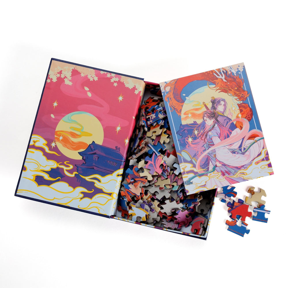  An open book-shaped box reveals puzzle pieces. Inner art on the top flap of pagoda at sunset. An anime style art print of Xingyin and Prince Liwei atop the pieces.
