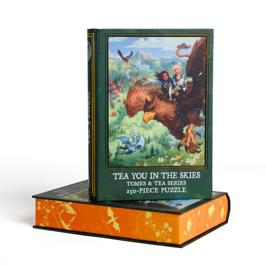 Book-shaped black box for Tea You in the Skies Tomes and Tea Series 250-piece puzzle. Art on the front is of Kianthe and Reyna flying on a griffin.