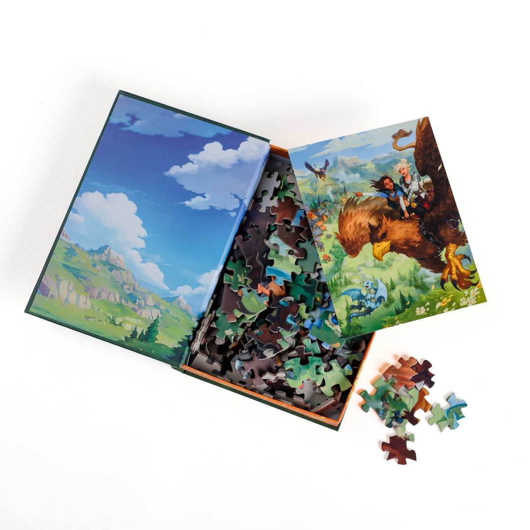 An open book-shaped box reveals puzzle pieces. Inner art on the top flap of a mountain and blue sky. An art print of Kianthe and Reyna flying on a griffin atop the pieces.