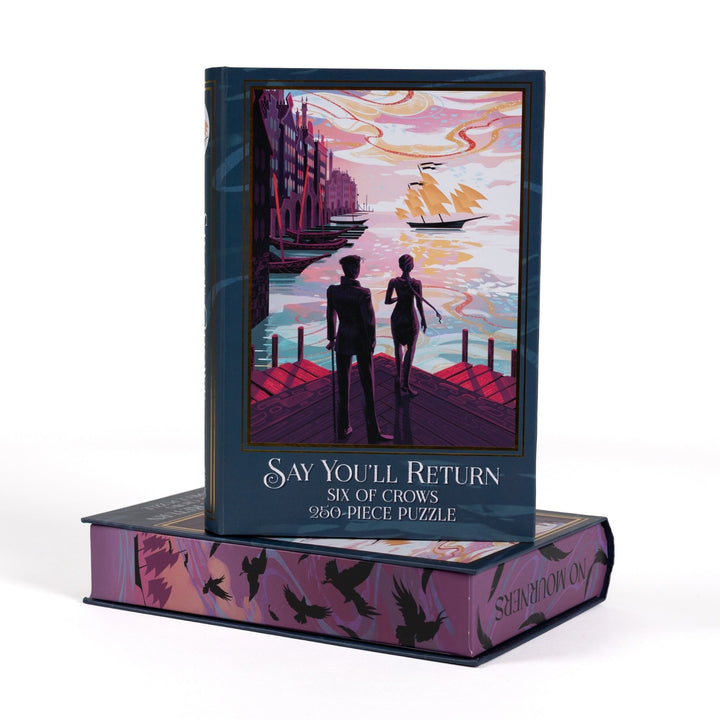 Book-shaped black box for Say You’ll Return Six of Crows 250-piece puzzle. Art on the front is of Kaz and Inej on the Ketterdam docks.