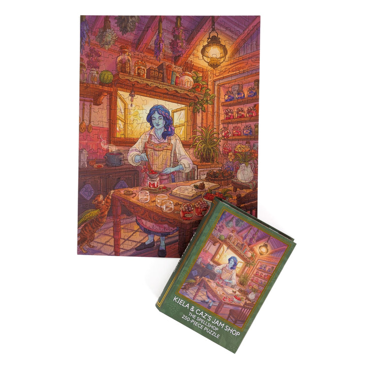 Full completed puzzle of Kiela in her kitchen and green, book-shaped box with matching art for Kiela and Caz’s Jam Shop The Spellshop 250-piece puzzle.