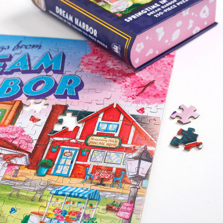 Close up of completed puzzle of the town square’s gazebo in the spring from Dream Harbor with one piece missing.