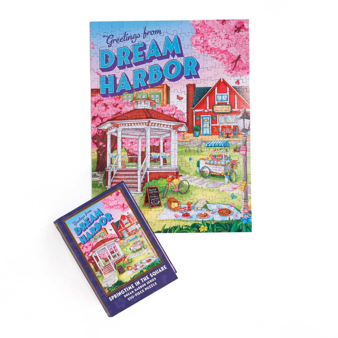 Completed puzzle of a gazebo in spring and purple, book-shaped box with matching art for Springtime in the Square Dream Harbor Series 250-piece puzzle.