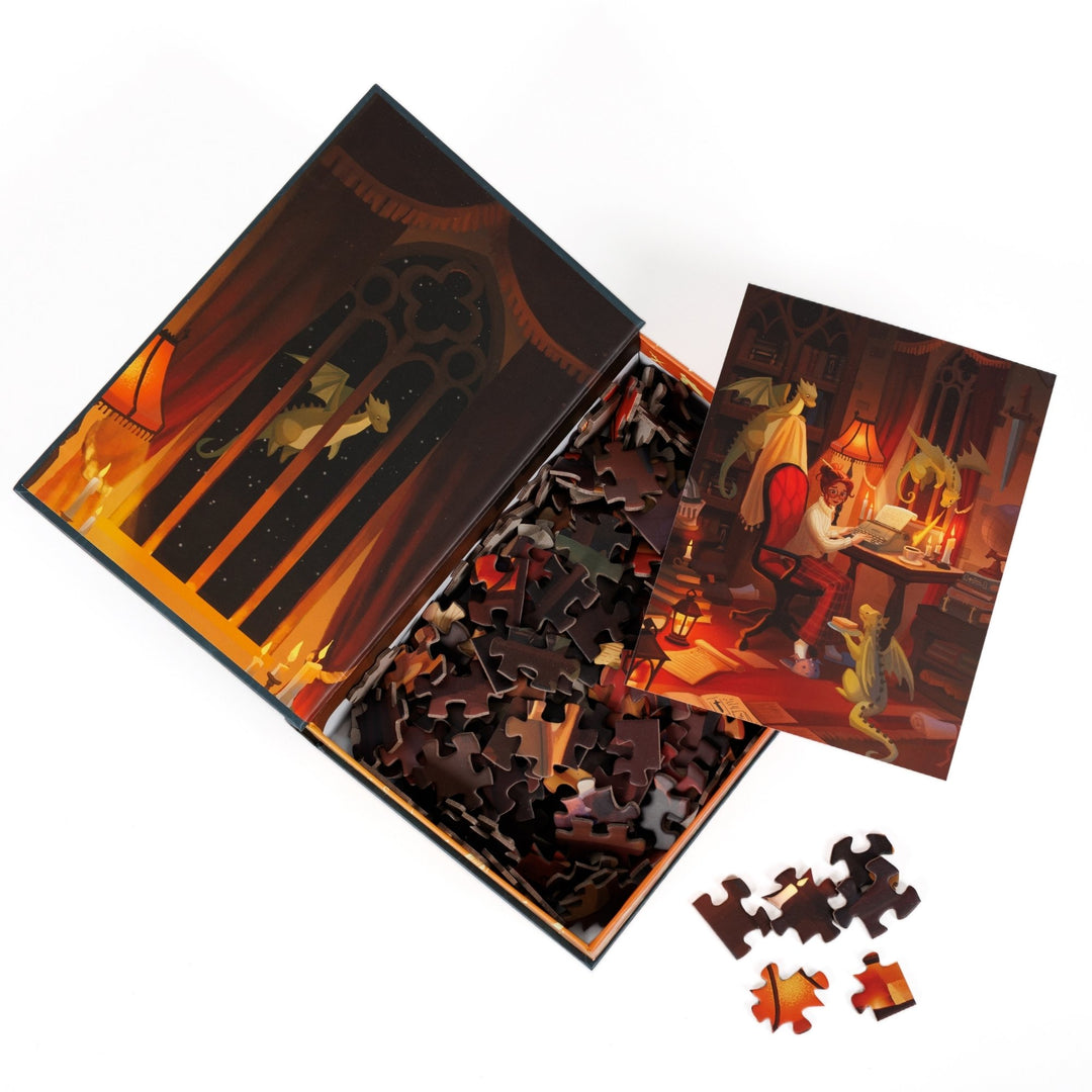An open book-shaped box reveals puzzle pieces. Inner art on the top flap of a candlelit window. An art print of a woman at a writing desk with three small dragons atop the pieces.