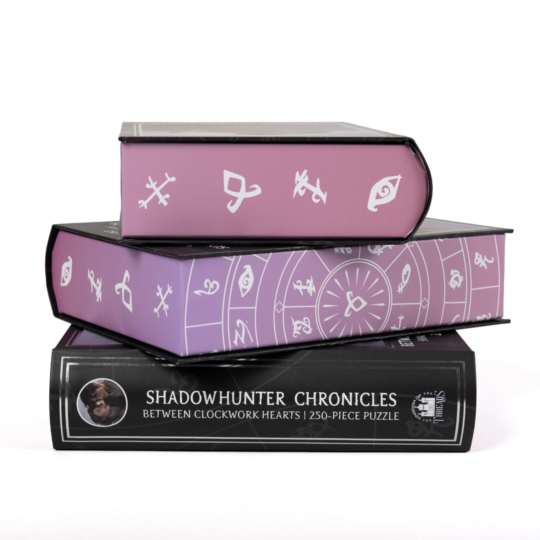 Stack of 3 puzzle boxes showing all sides. Purple edges with white Shadowhunter runes. The spine of the box reads Shadowhunter Chronicles Between Clockwork Hearts 250-piece puzzle.
