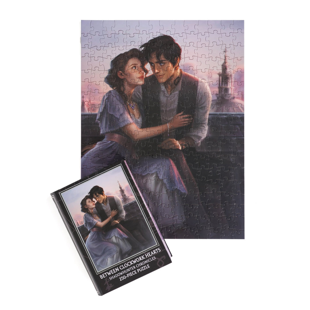  Full completed puzzle of Will and Tessa on a London rooftop and black, book-shaped box with matching art for Between Clockwork Hearts Shadowhunter Chronicles 250-piece puzzle.