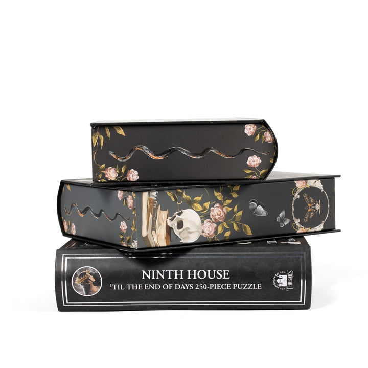 Stack of 3 puzzle boxes showing all sides. Black edges with illustrated snakes and skulls. The spine of the box reads ‘Ninth House Til the End of Days 250-piece puzzle.’